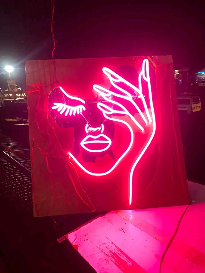 Custom neon face sign by Zus Signs — glowing magenta line art